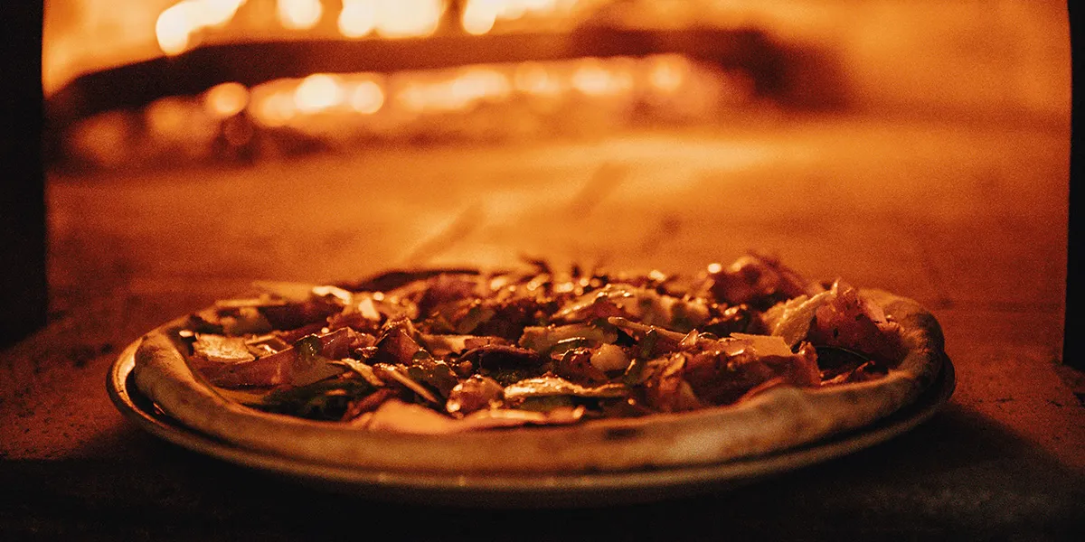 Freshly baked pizza next to the oven